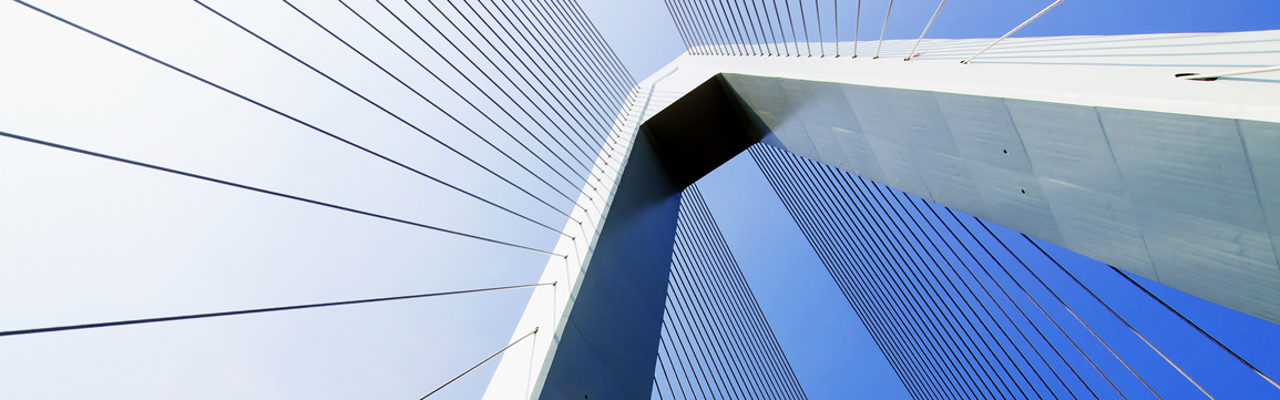 Low-angle view looking up at a modern white cable-stayed bridge pylon and fan-patterned steel cables against a clear blue sky, symbolizing strength and structural resilience.